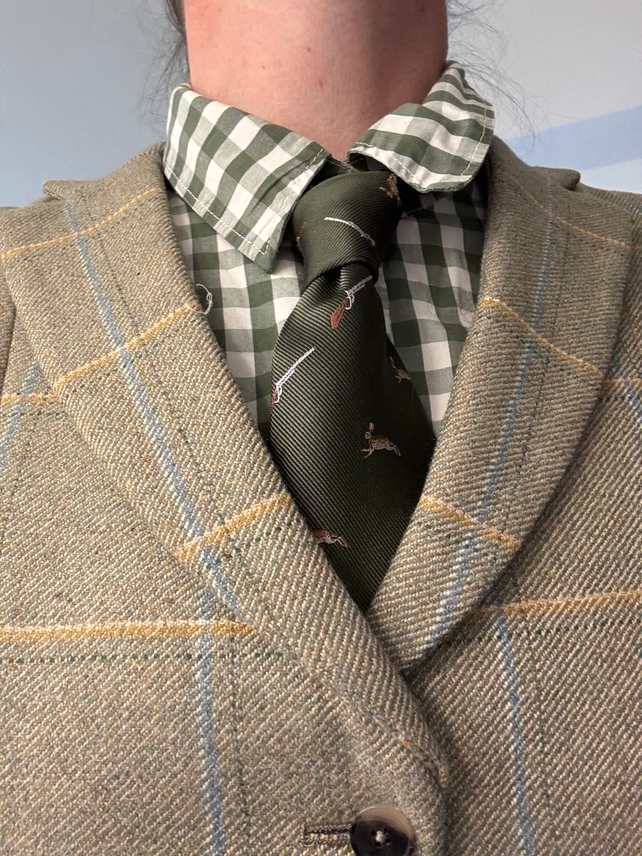 Tweed vest over a green gingham shirt with an olive pheasant tie